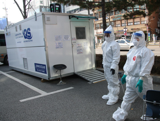 휴일인 21일 서울 강남구의  신종 코로나바이러스 감염증(코로나19) 선별진료소에서 관계자들이 검사대기 시민들을 기다리고 있다. [연합뉴스]